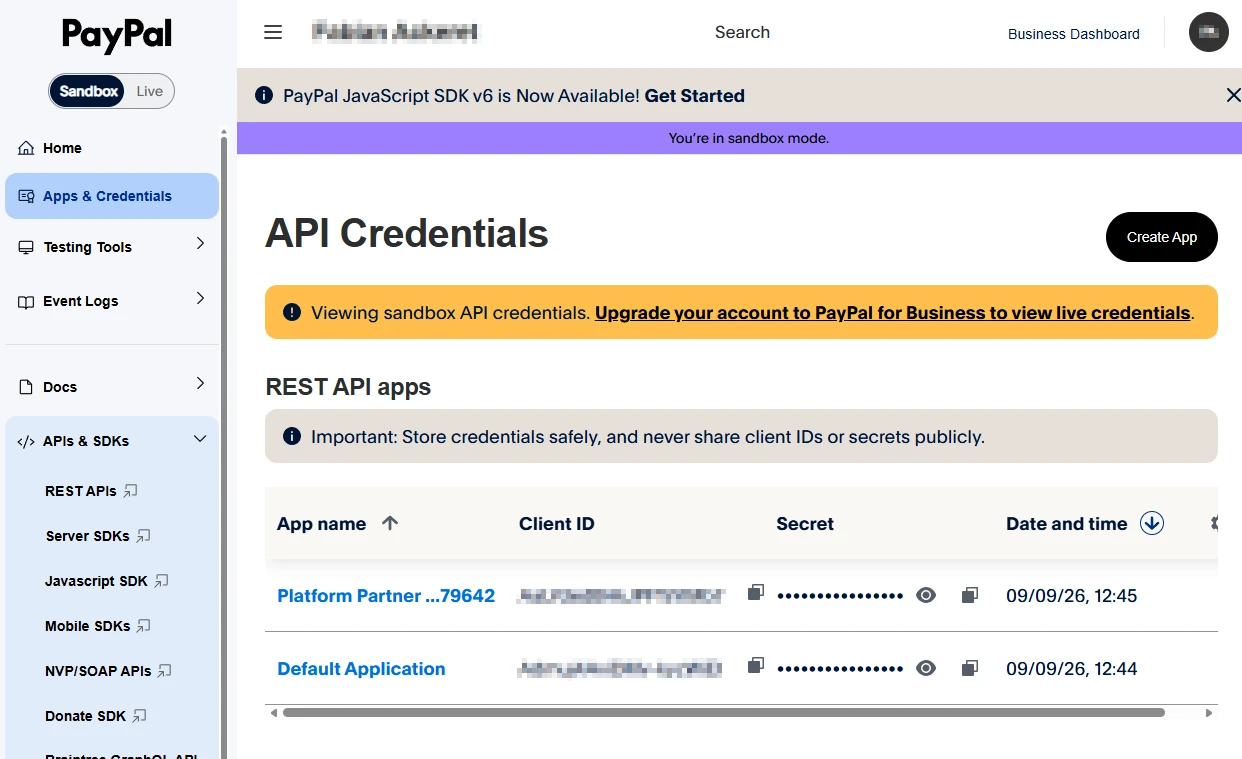 The PayPal developer dashboard on Apps & Credentials, listing REST API apps with their client IDs and secrets.